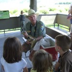 Chuck with Hatch on Elk Refuge deck Chuck discusses bullsnake with young visitors.